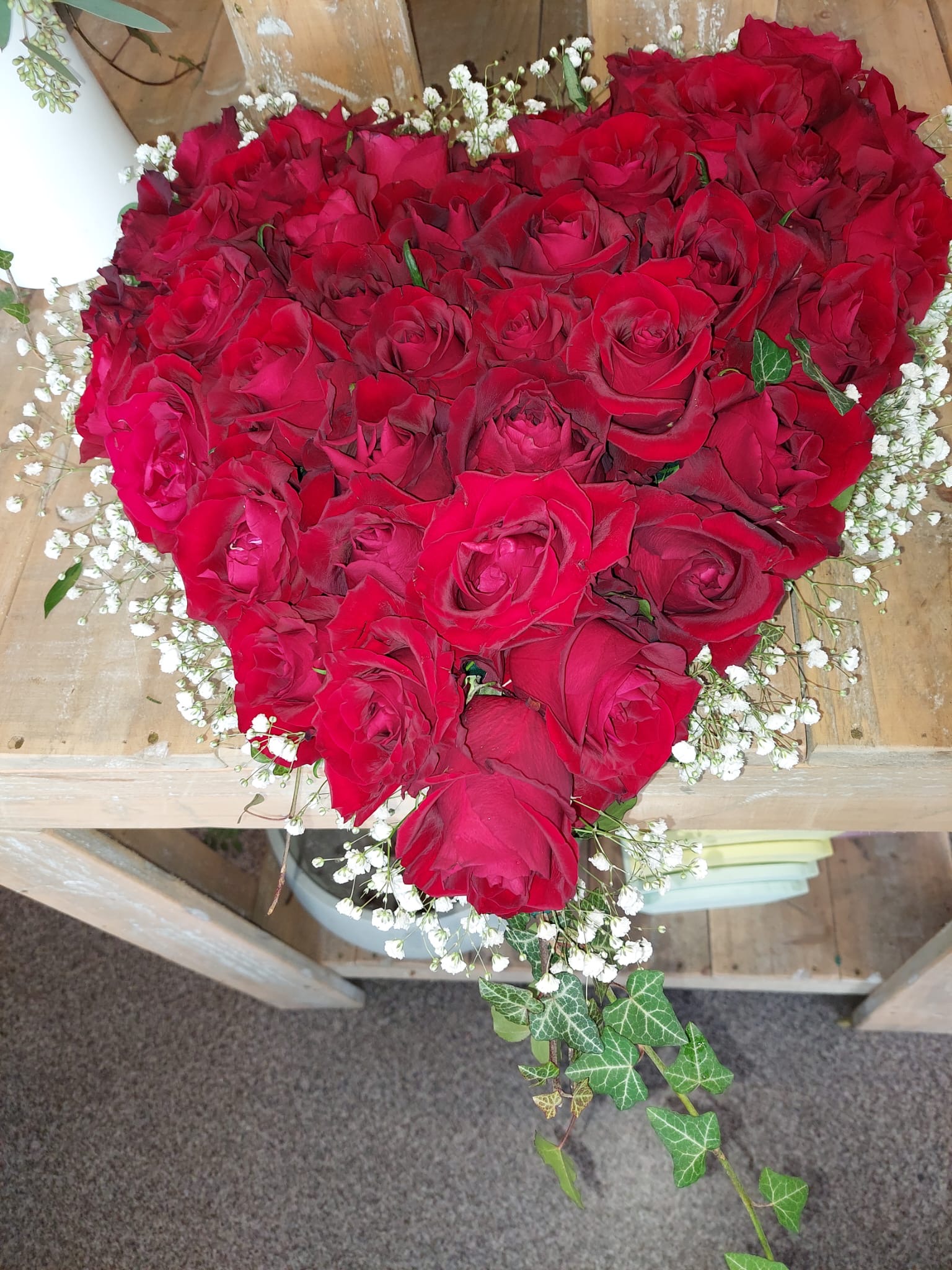 Herzförmiges Gesteck aus roten Rosen mit Schleierkraut